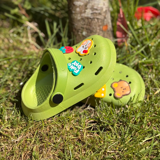 Groene kinderklompjes met vrolijke figuren