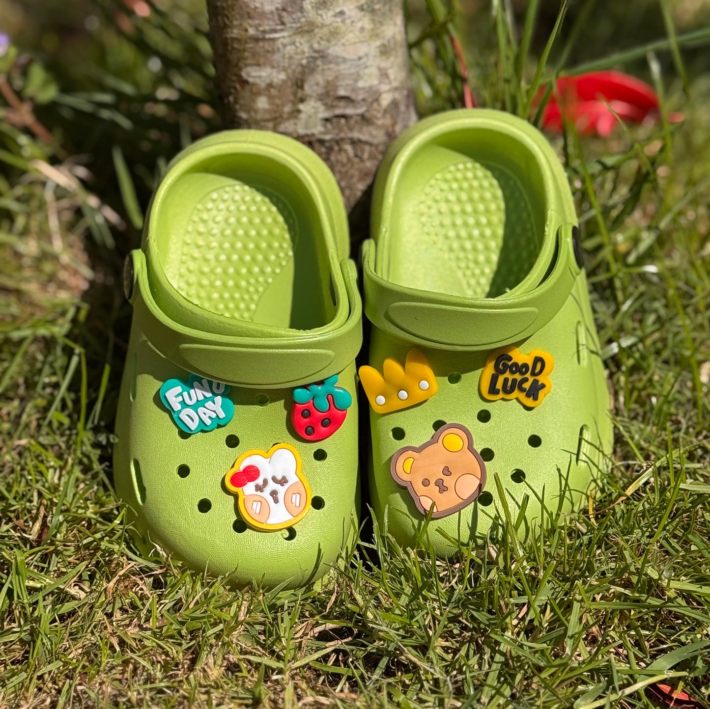 Groene kinderklompjes met vrolijke figuren