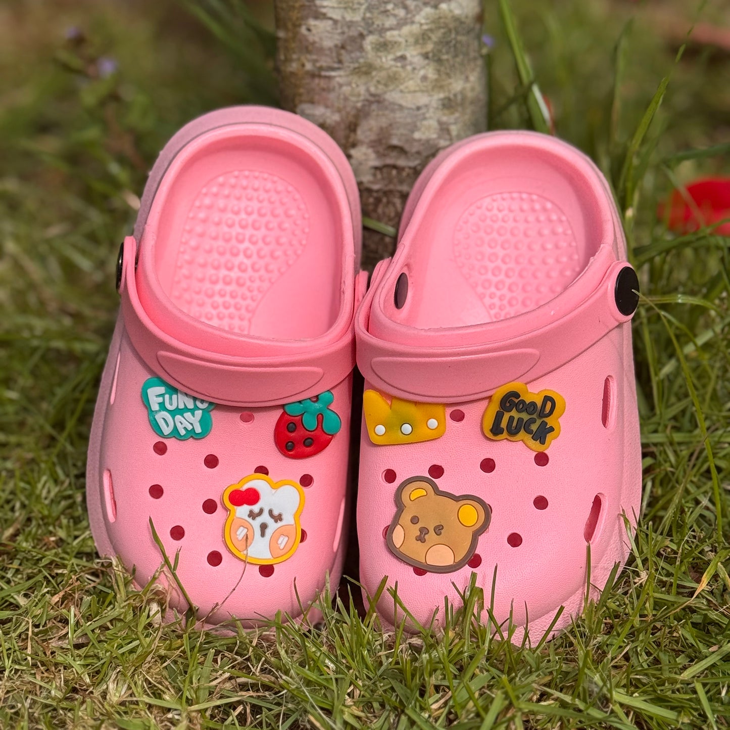 Roze kinderklompjes met vrolijke figuren