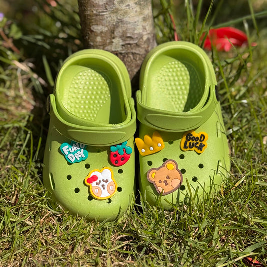 Groene kinderklompjes met vrolijke figuren