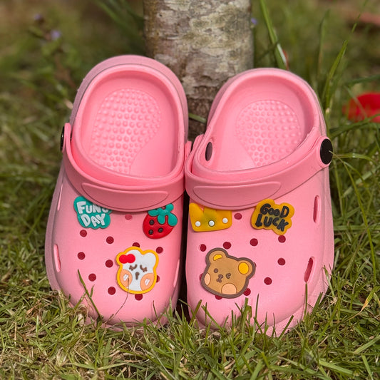 Roze kinderklompjes met vrolijke figuren