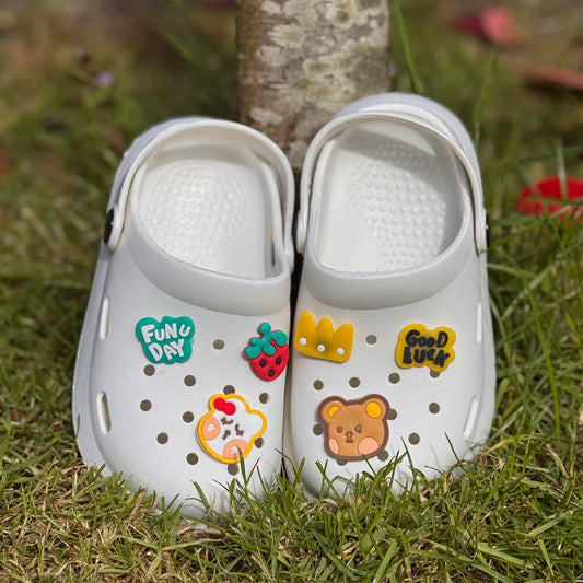 Witte kinderklompjes met vrolijke figuren
